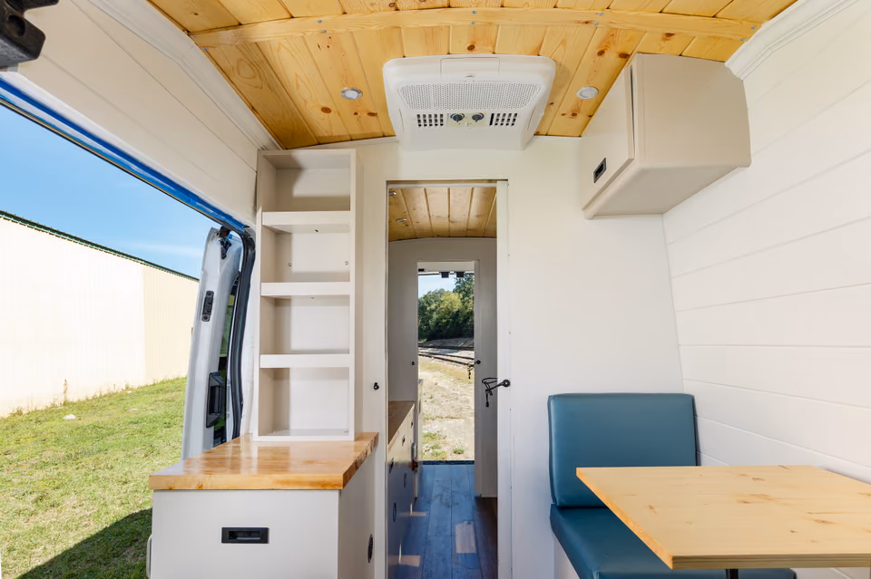 Mobile business van interior with desk, printer, and customer seating